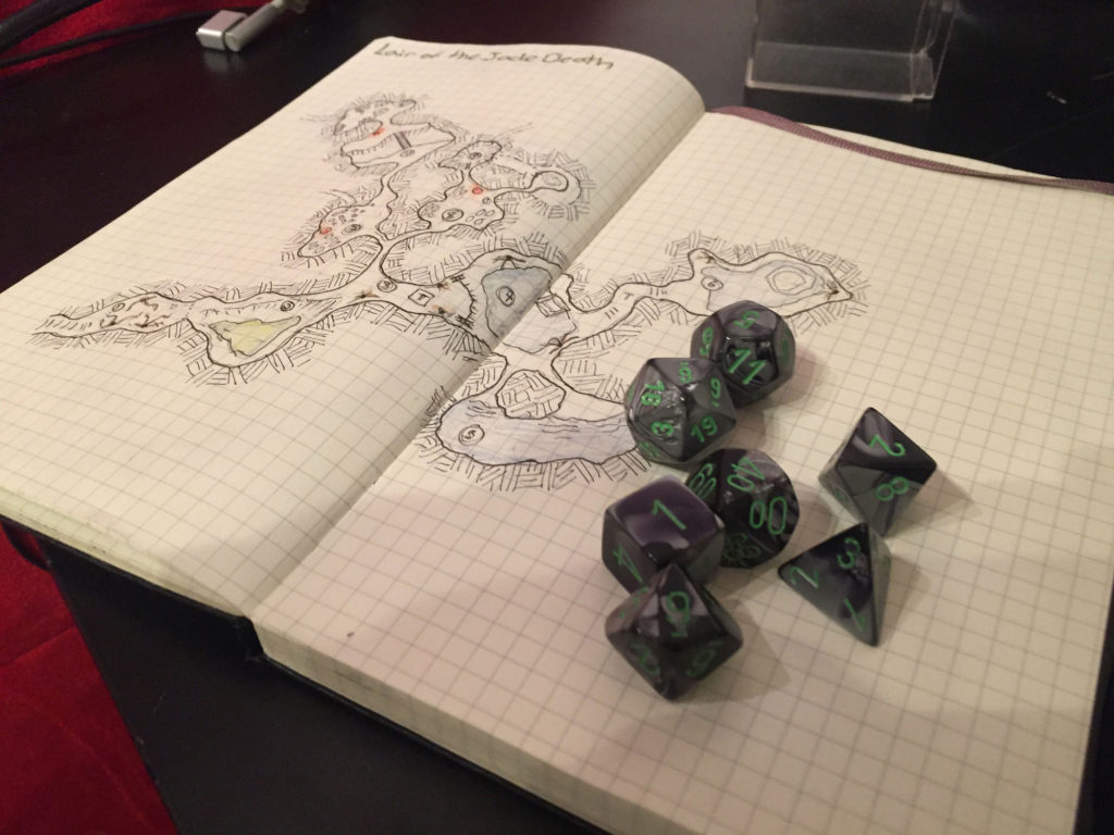 Green and grey dice sit atop a hand-drawn dungeon map. 