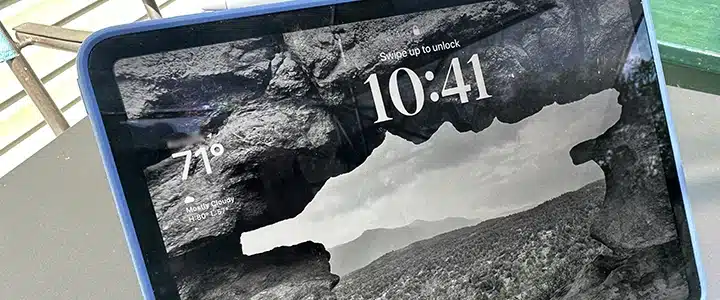 The iPad Pro, opened to its lock screen. The lock screen depicts a stone arch, with a desert/scrub landscape in the background.
